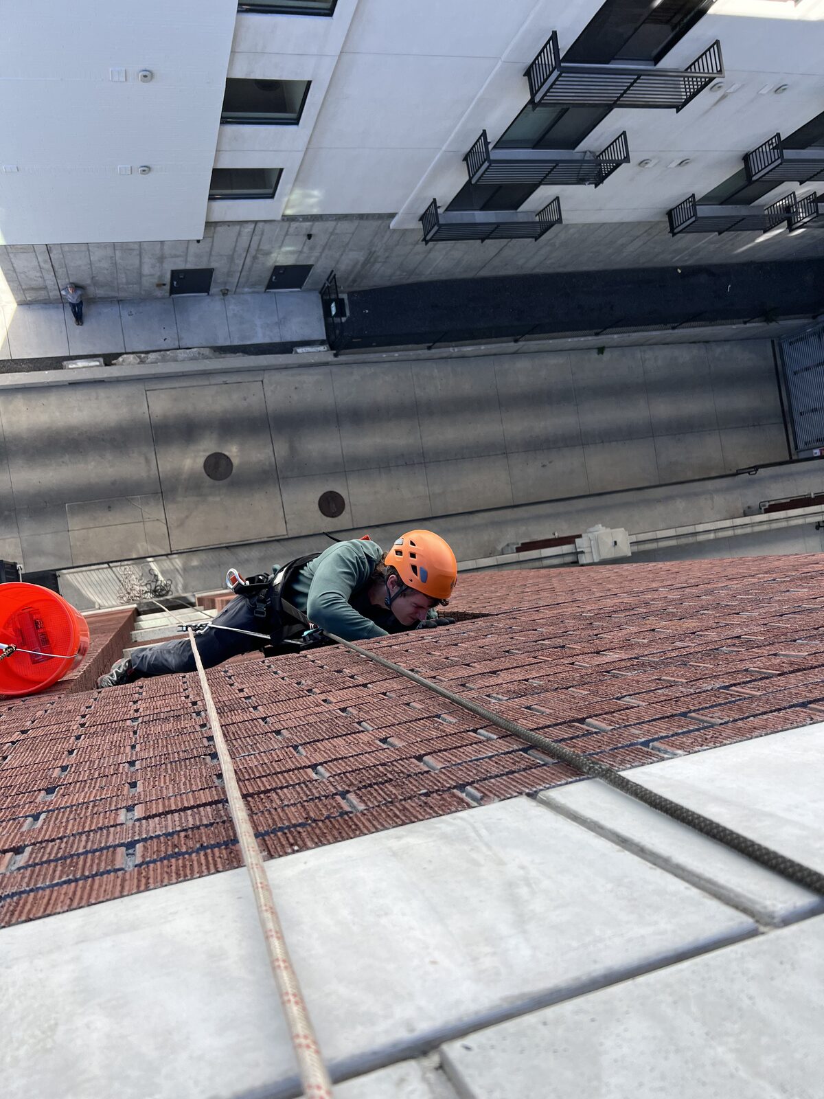 Rope-access technician inspecting brickwork on a tall building